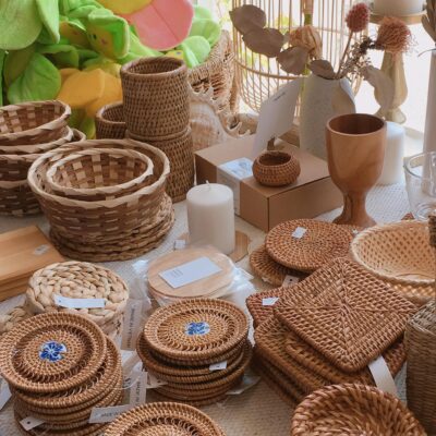 A warm display of handmade wicker and rattan accessories including baskets and coasters.